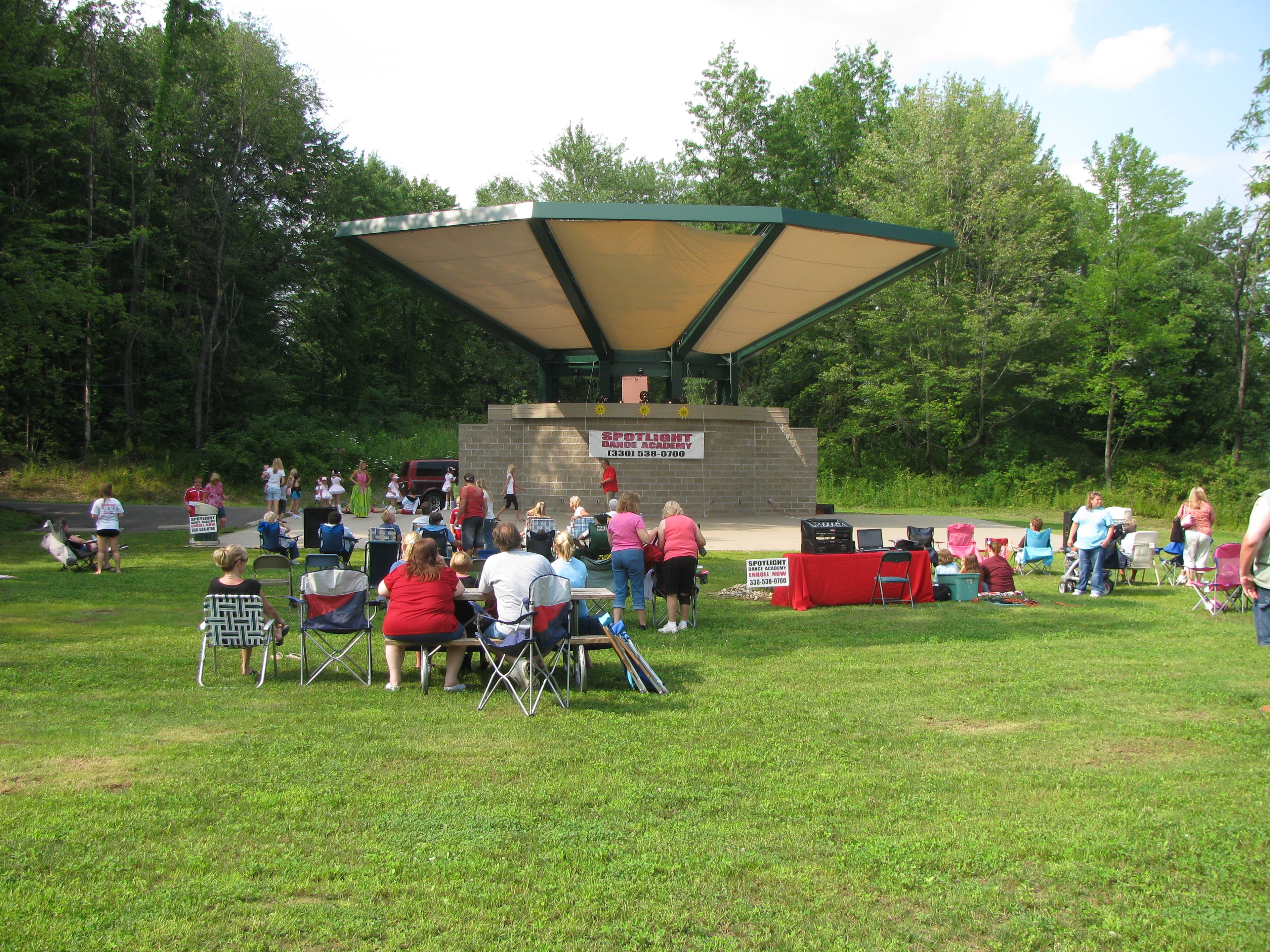 An event with visitors sitting on a grassy lawn at Lake Milton State Park