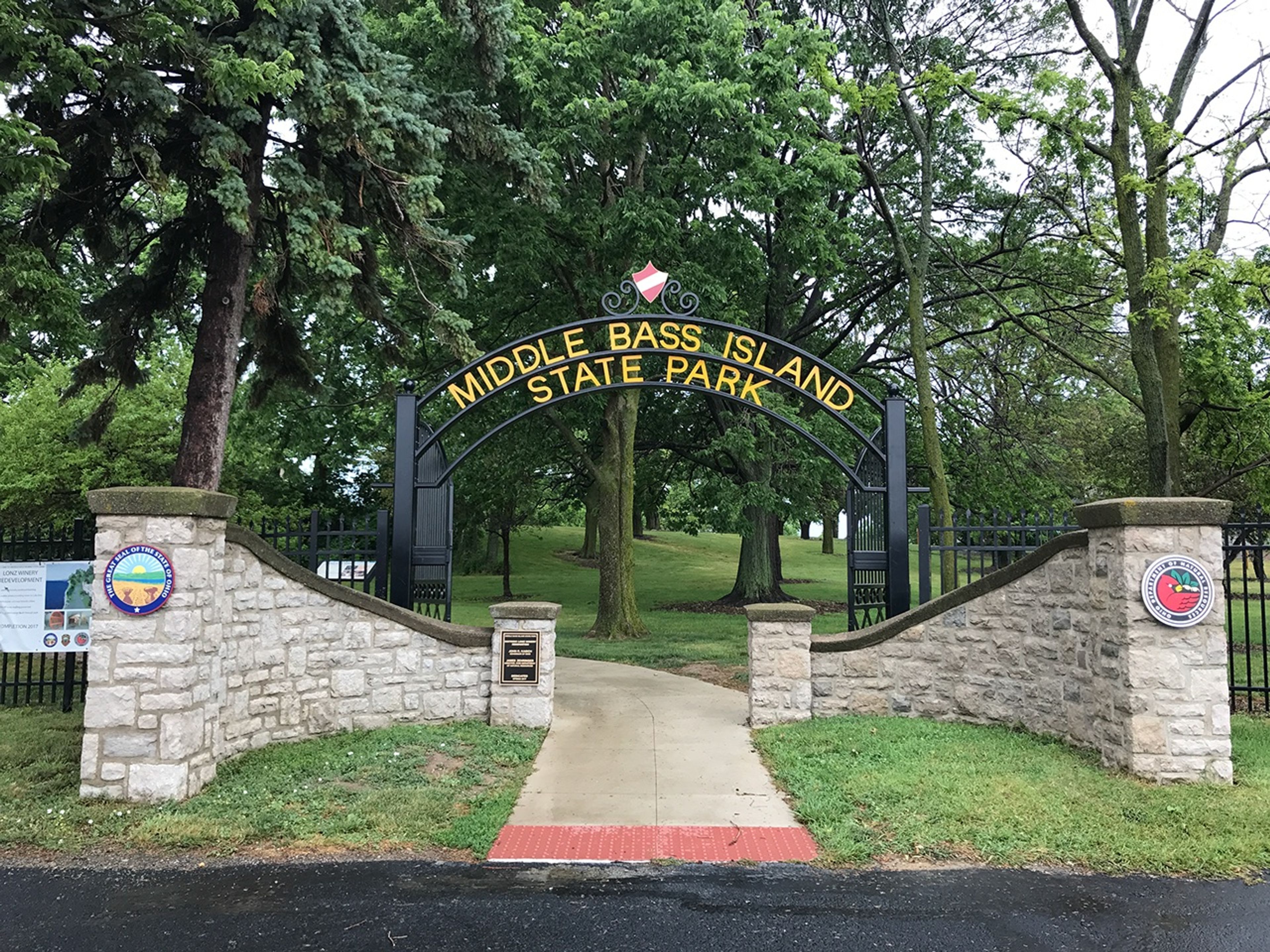 Sign that reads Middle Bass Island State Park at the entrance of a sidewalk.