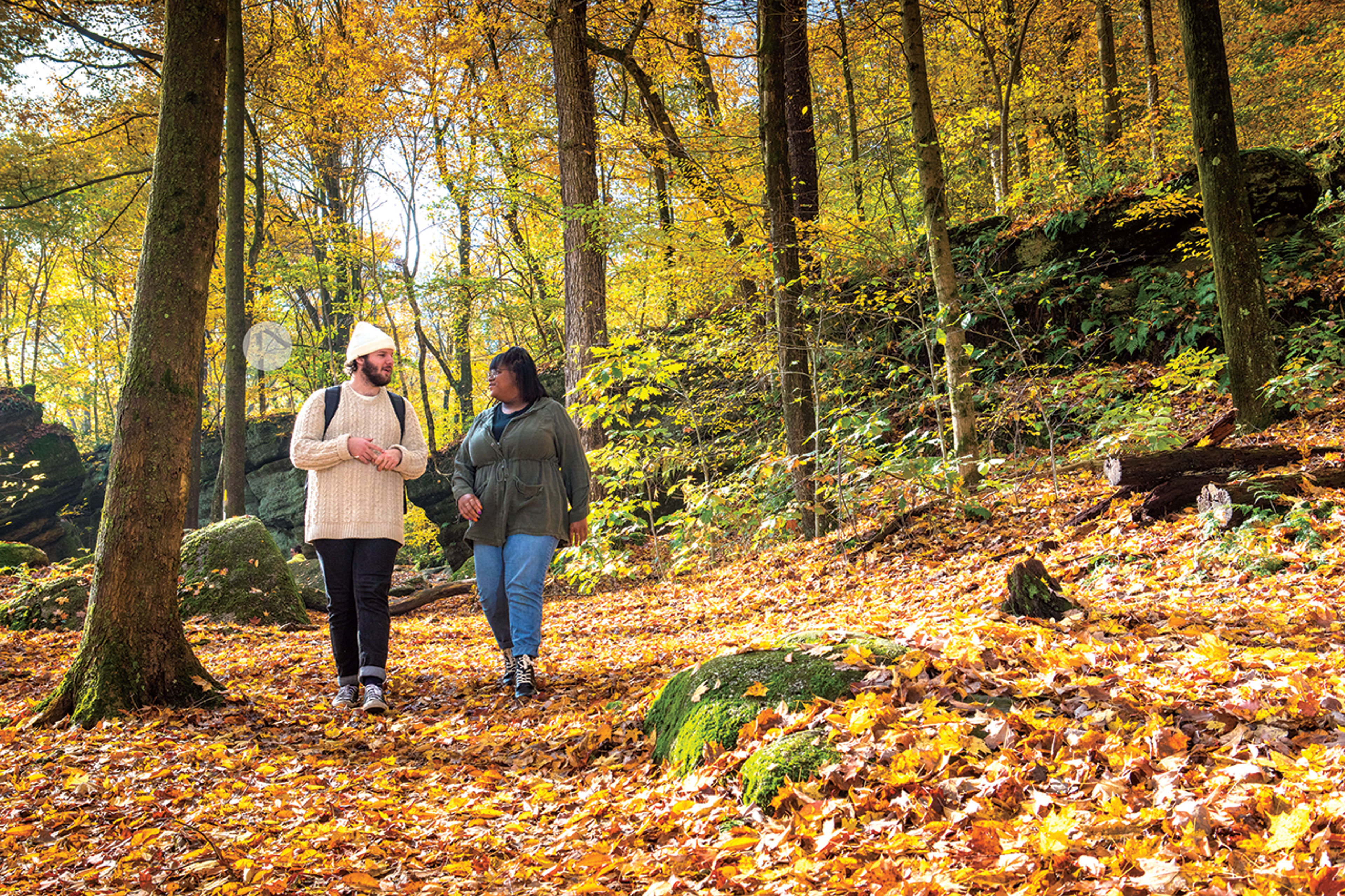 Two people walking through the woods at Nelson-Kennedy Ledges State Park