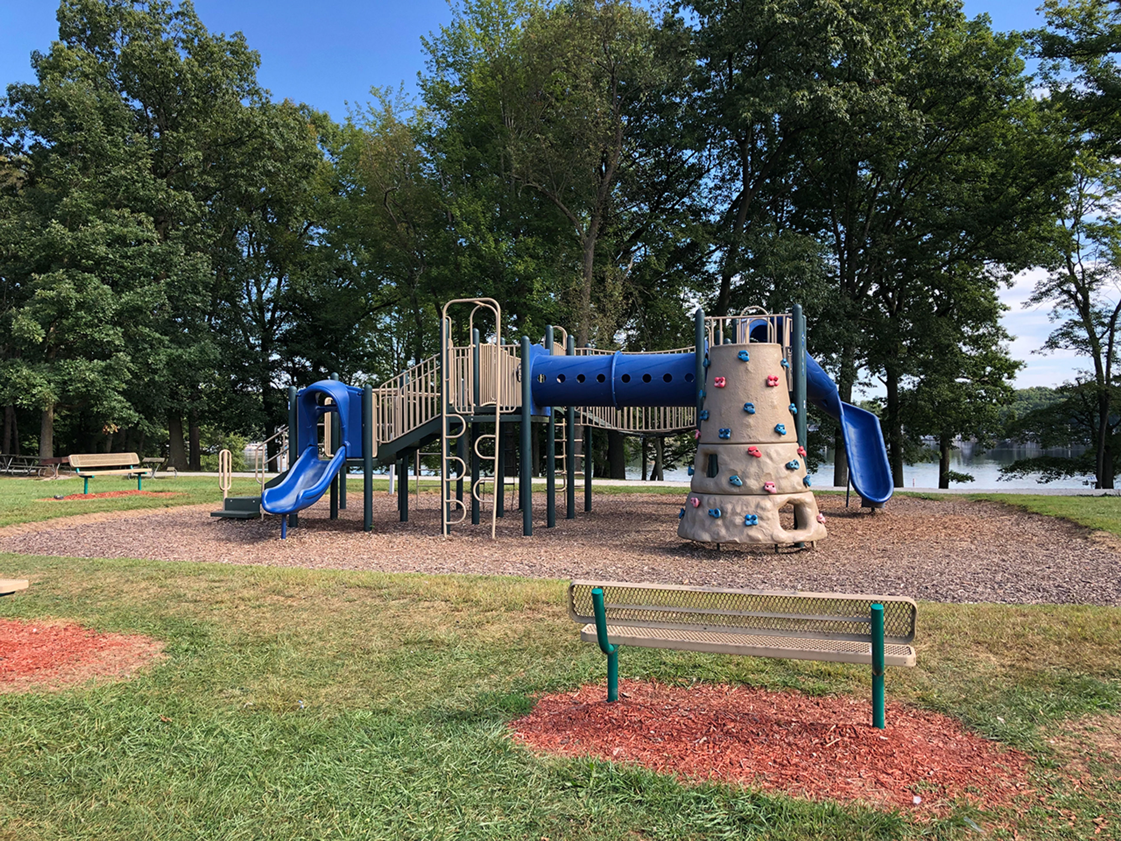 Park bench in front of a playground at Portage Lakes State Park