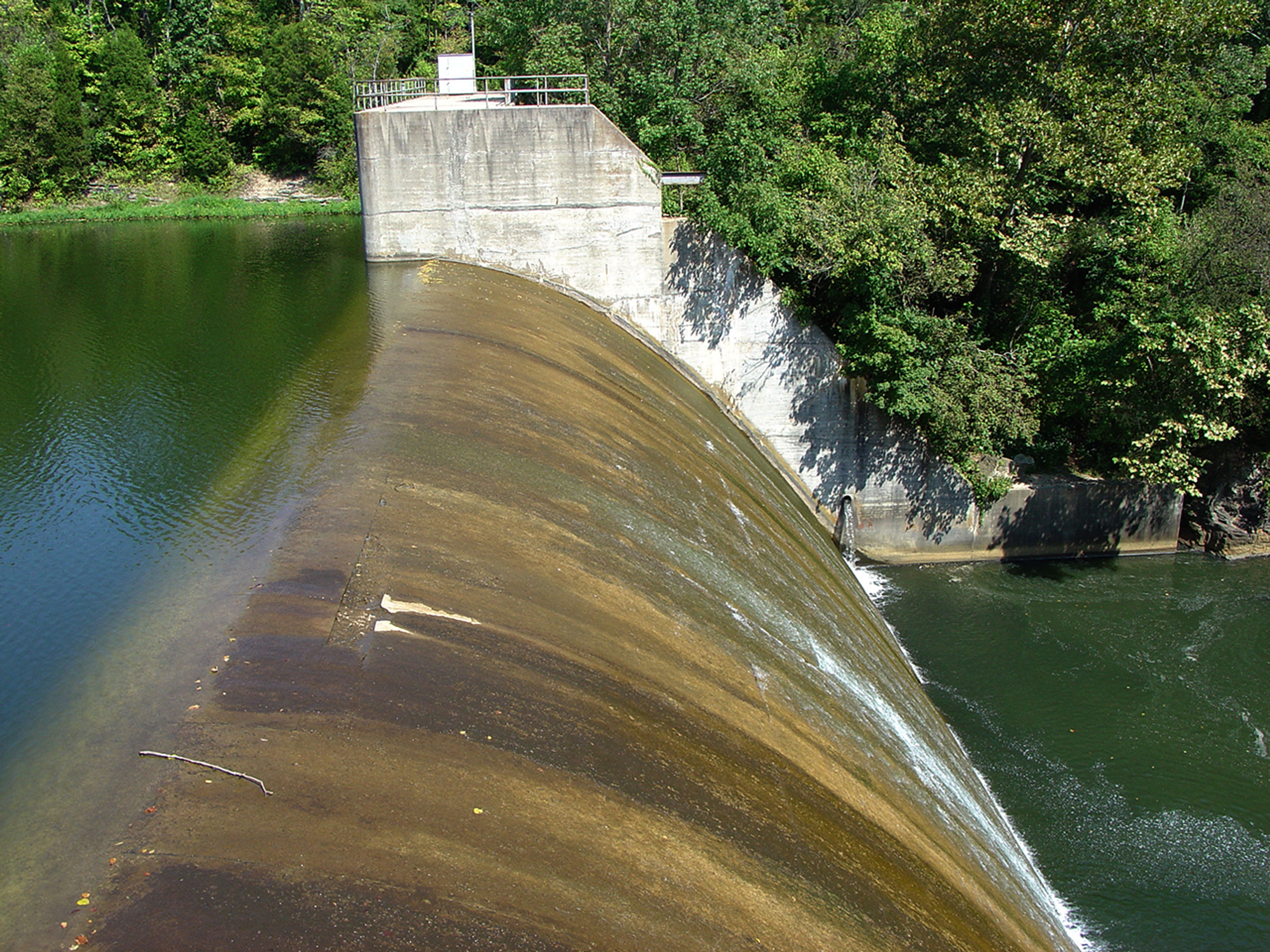 A concrete dam with water flowing over it at Rocky Fork State Park