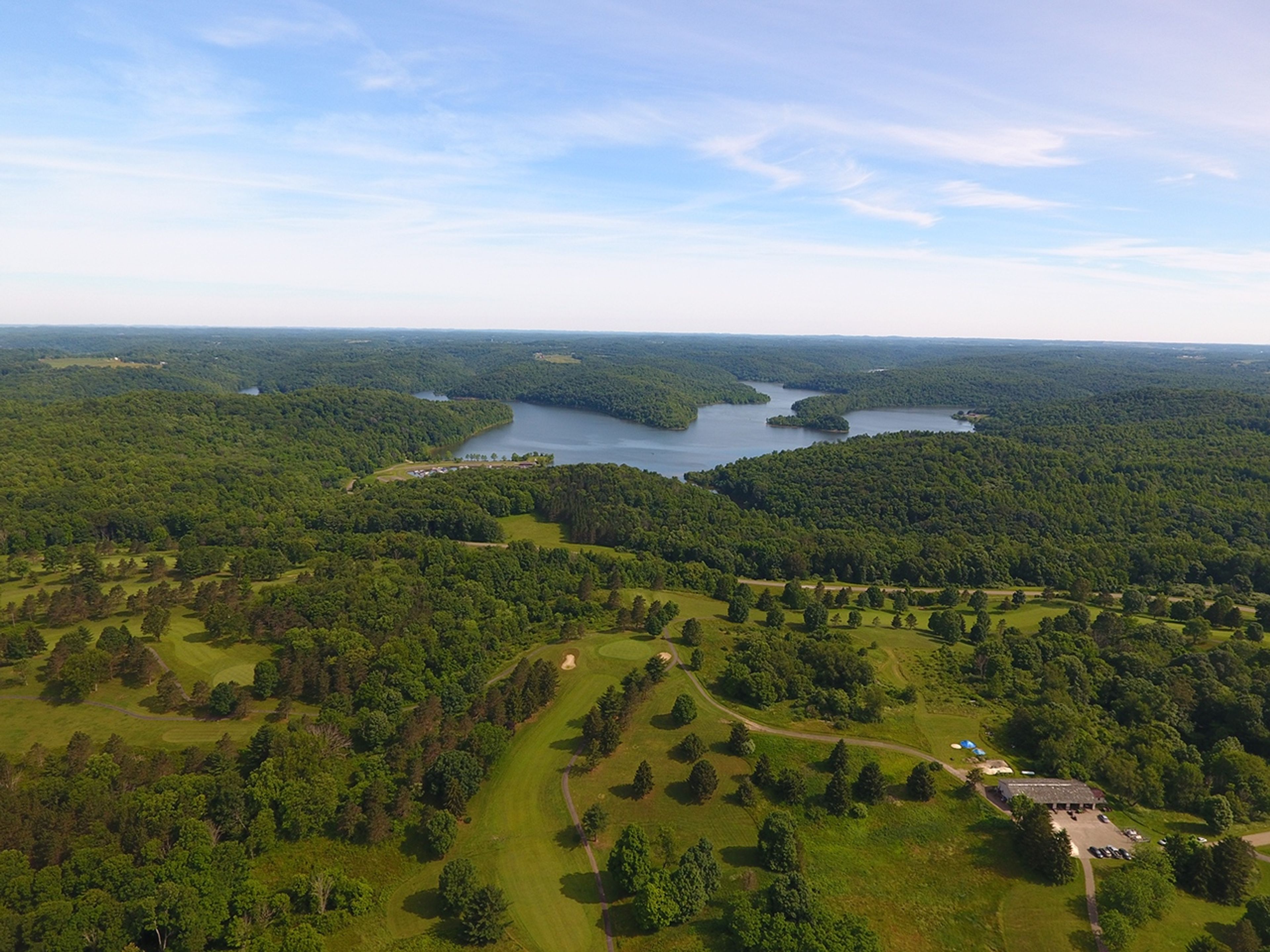 An aerial view of a golf course with a body of water at Salt Fork State Park