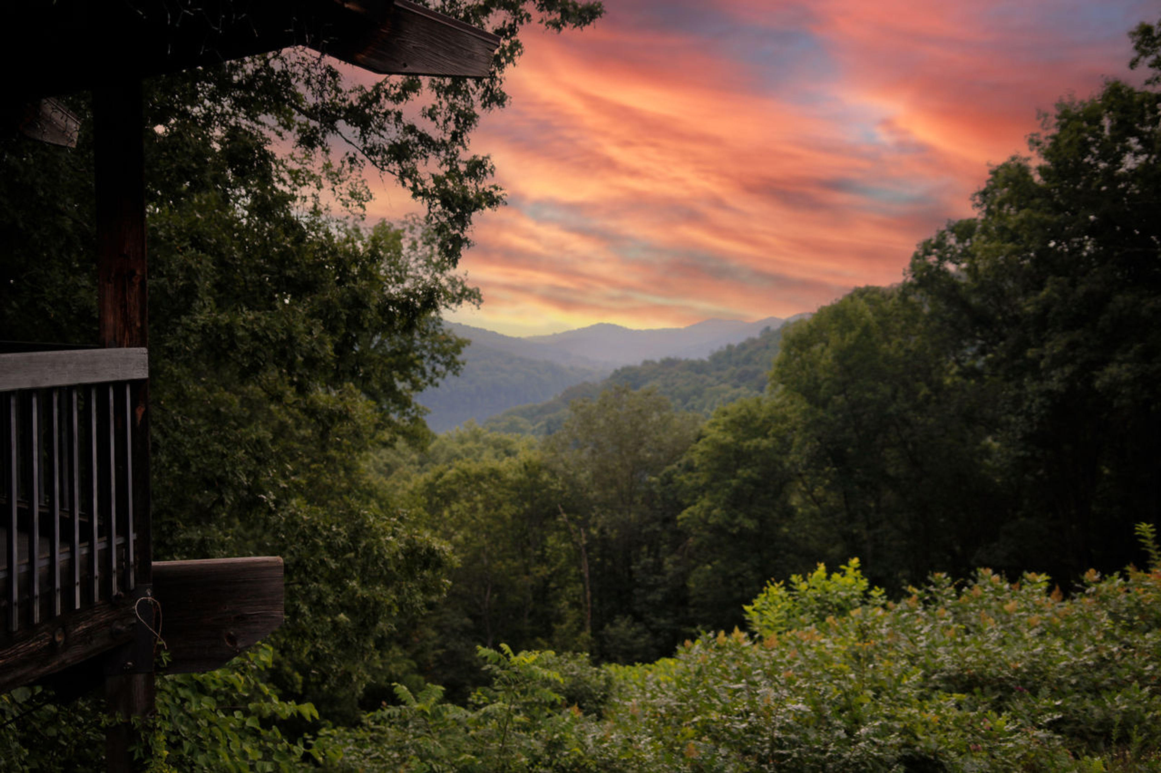 Sunrise over a forest from a cabin porch at Shawnee State Park