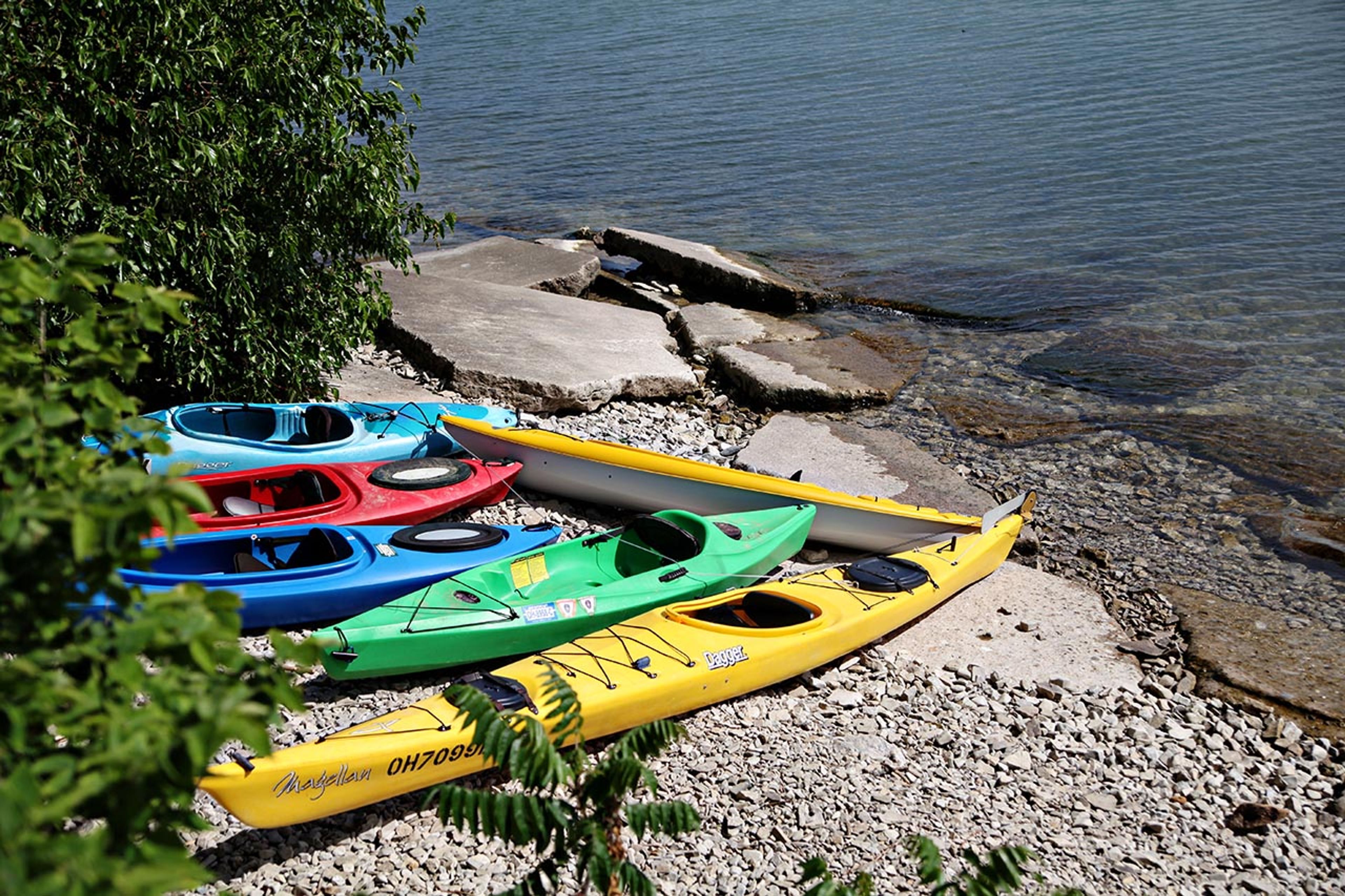 A group of kayaks on a rocky shore at South Bass Island State Park