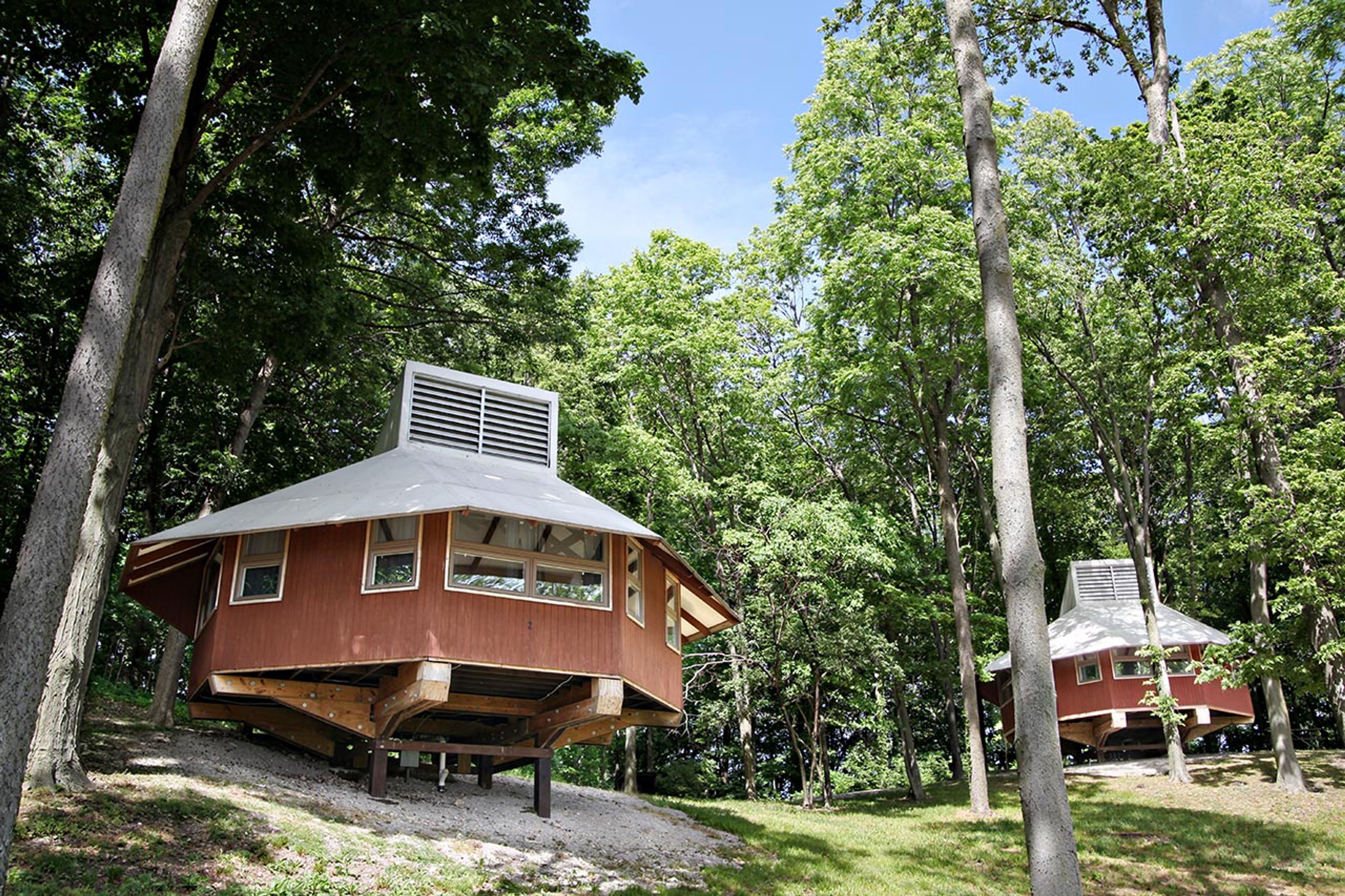 Two cabins on stilts in a forest at South Bass Island State Park