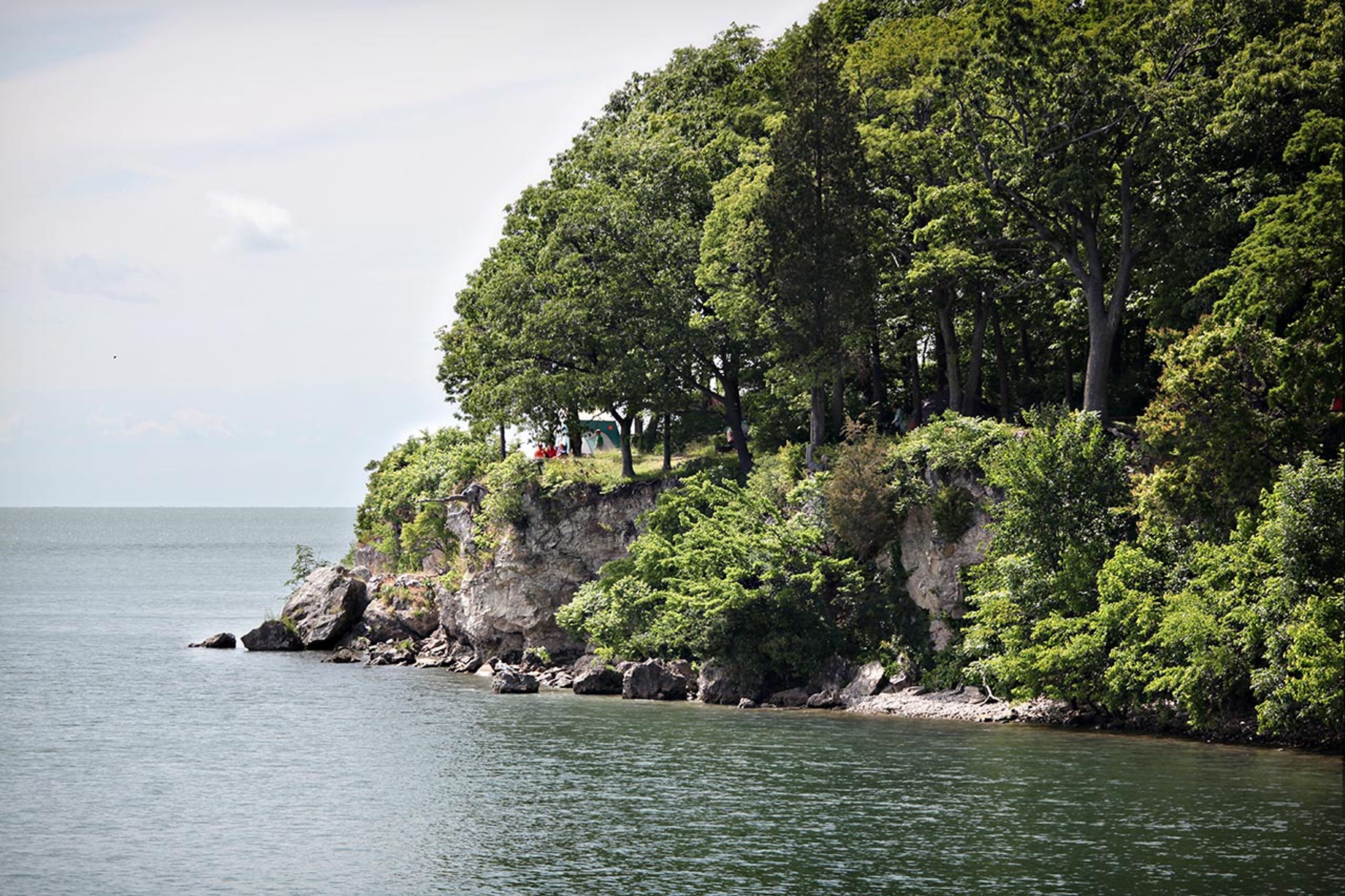 A body of water with trees on a cliff at South Bass Island State Park