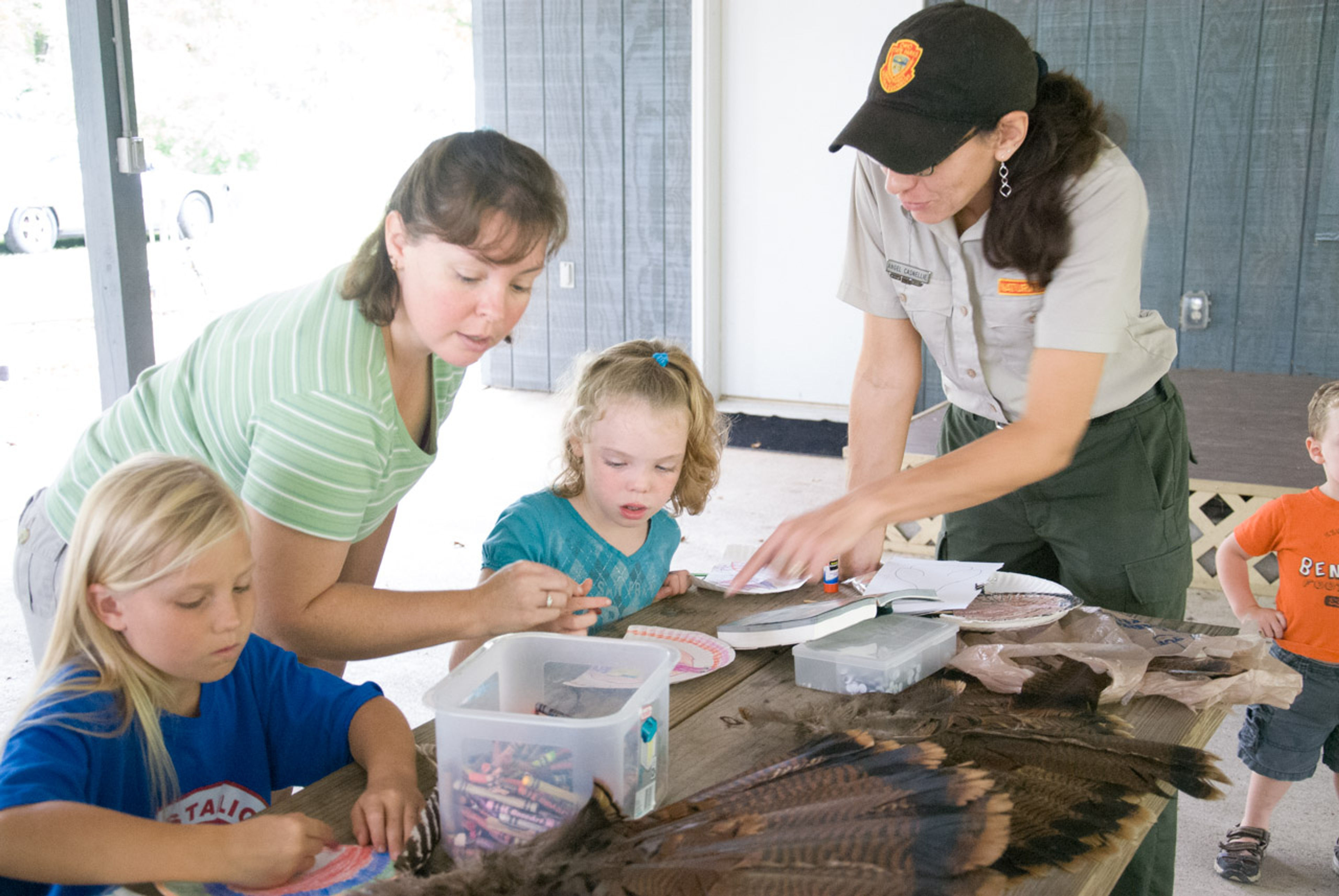 ODNR employee helping two children color at Stonelick State Park