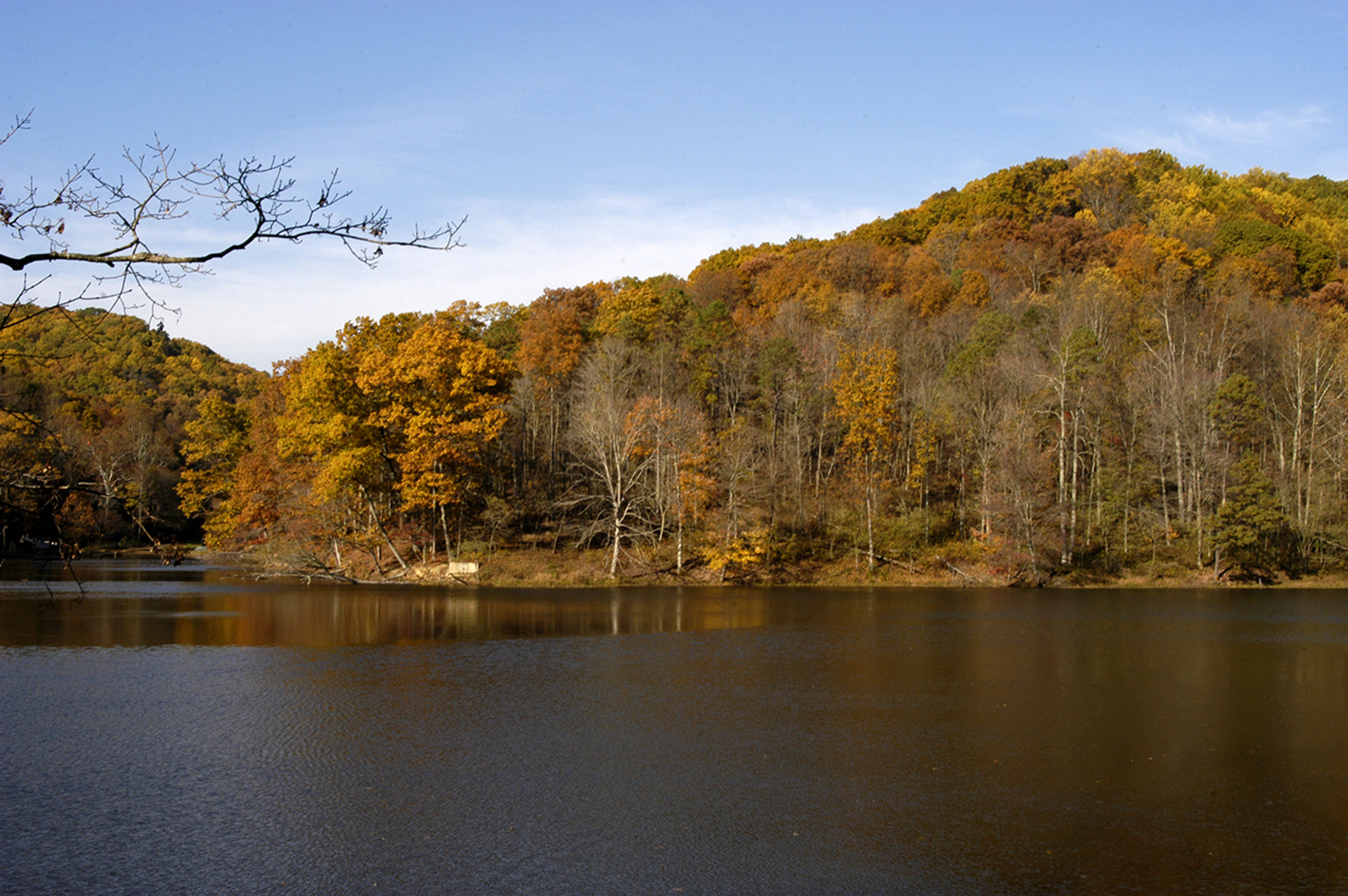 A person sitting in a chair next to a tent at Tar Hollow State Park