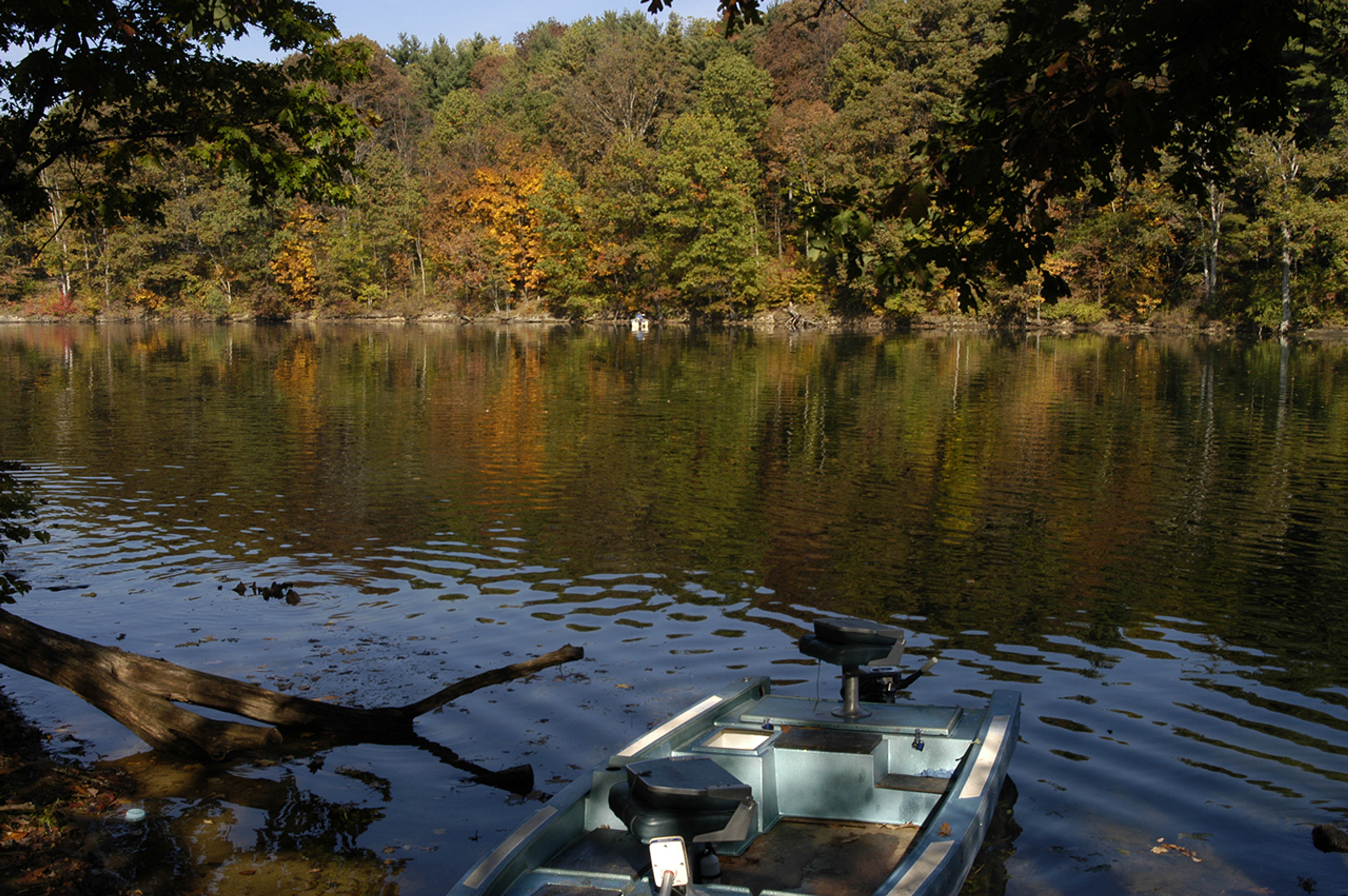 Small boat parked on the side of a lake at Wolf Run State Park