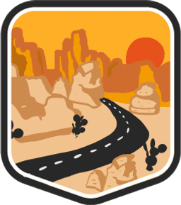 An illustrated badge for the Colorado community depicting a road running through rock formations under a setting sun.