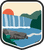 An illustrated badge for the Georgia community showing a waterfall cascading into a river surrounded by lush green hills.