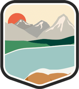 An illustrated badge for the Idaho community showing a lake surrounded by mountains with a clear sky.