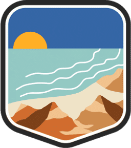 An illustrated badge for the Martha’s Vineyard community depicting a coastal scene with sandy beaches, with rock formations, and the ocean.