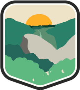 An illustrated badge for the New Hampshire community showing a forest with tall pine trees in the foreground and a river in a valley heading towards a setting sun in the background.