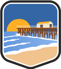 An illustrated badge for the New Jersey community depicting a beach scene with a boardwalk and the ocean under a blue sky.