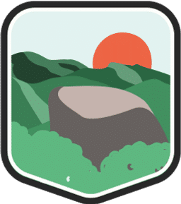 An illustrated badge for the North Carolina community depicting an ancient, forested mountain range with the sun setting in the background.