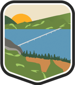 An illustrated badge for the South Dakota community featuring a lake with a bridge crossing it against a backdrop of rolling hills and a clear sky.