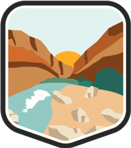 An illustrated badge for the Texas community showing a desert canyon with rocky cliffs and a river flowing through it under a clear blue sky.