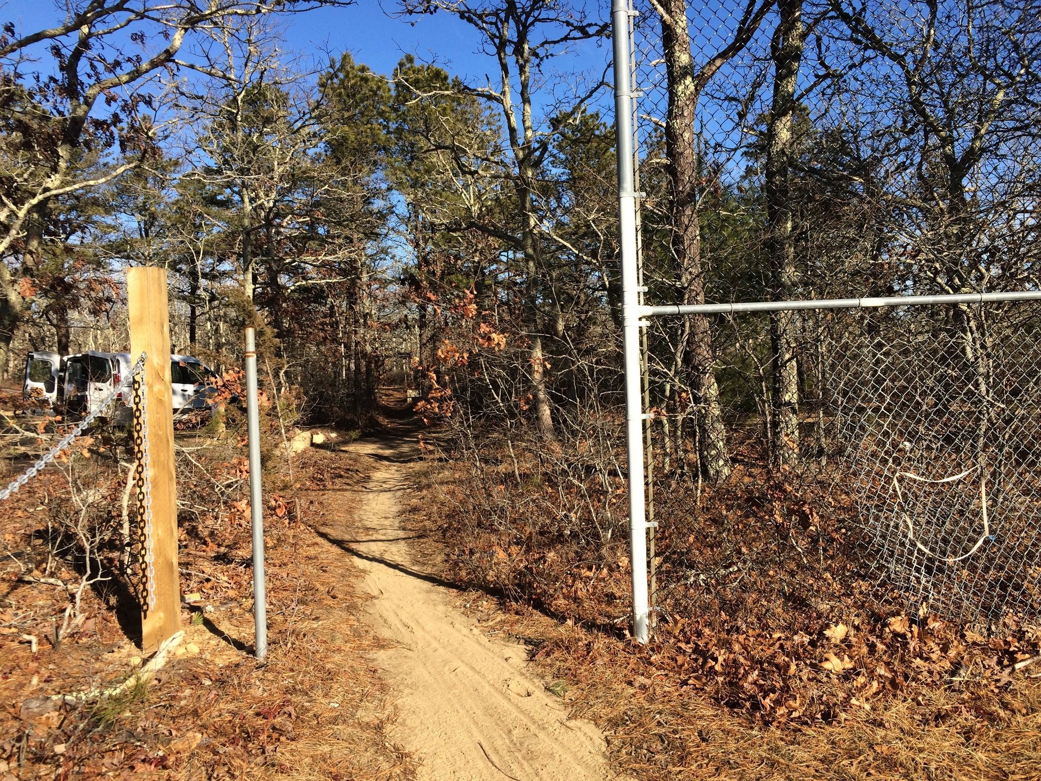 narrow sandy path leading to paved bike path