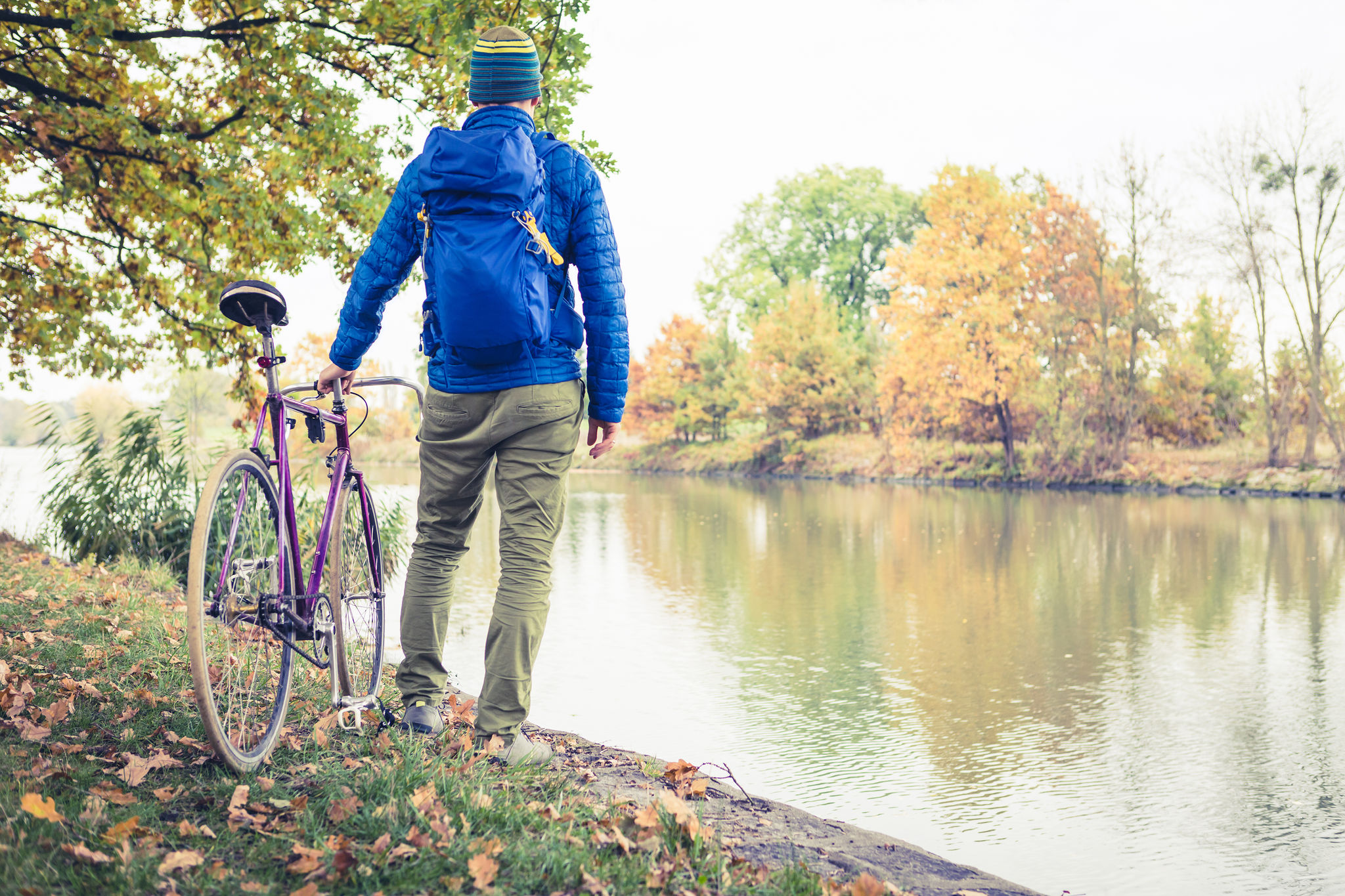 man-with-road-bike-looking-at-river-view-in-park-PAJ5NLN.jpg