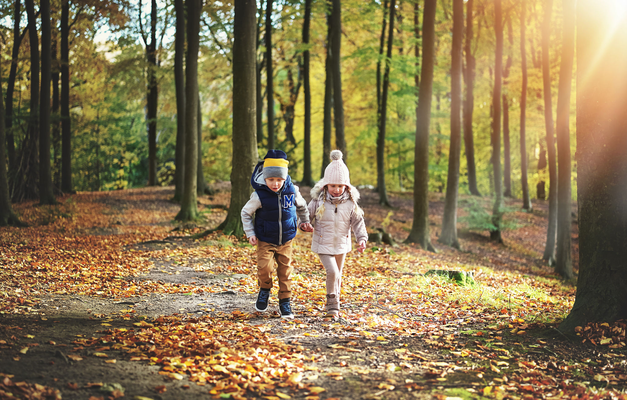 two-kids-wandering-in-the-autumn-forest-PK9A26H.jpg