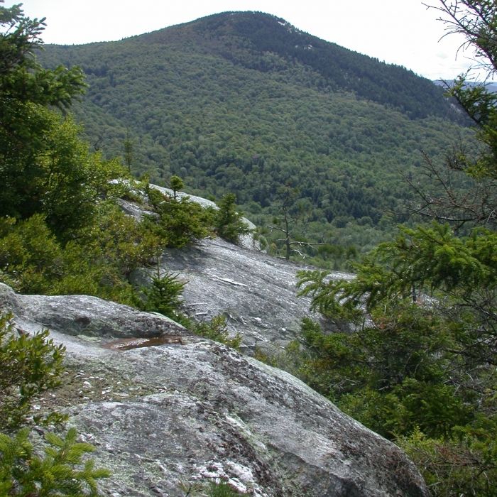 A view of a mountain above granite boulders.