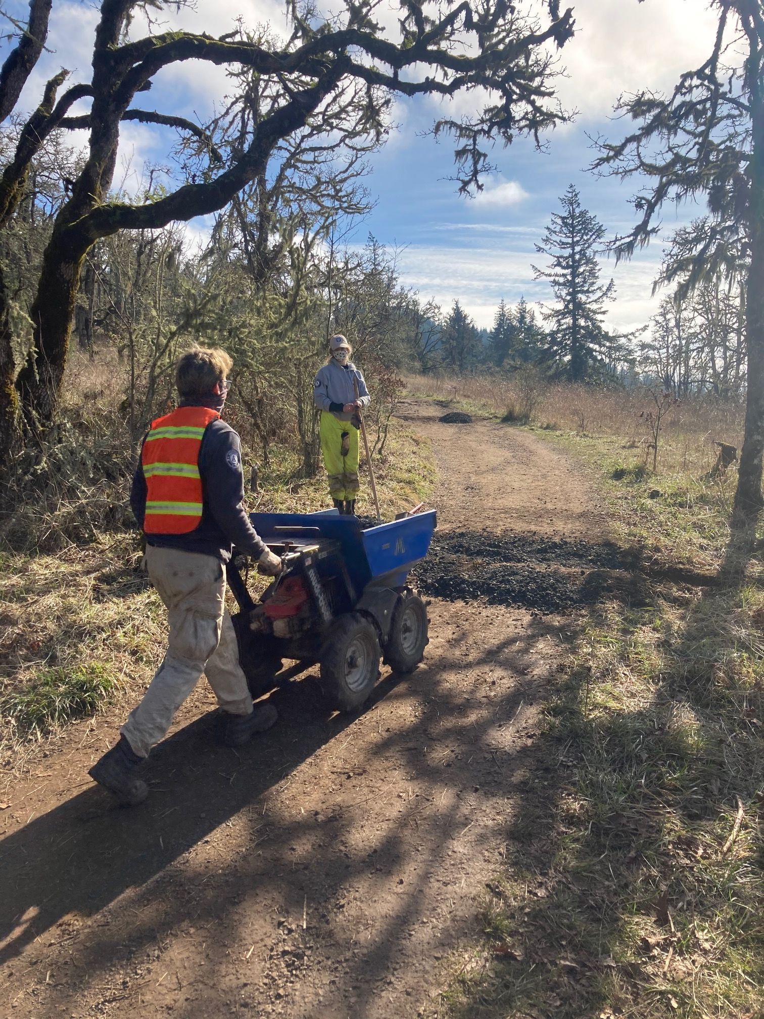 Americorps NCCC crew work to place gravel on rolling dips on upper Trail 1