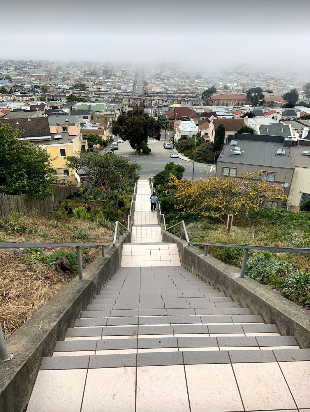 Moraga-16th Steps looking west, showing nothing but stair treads, and fog-draped Sunset District on a classic SF summer day. 