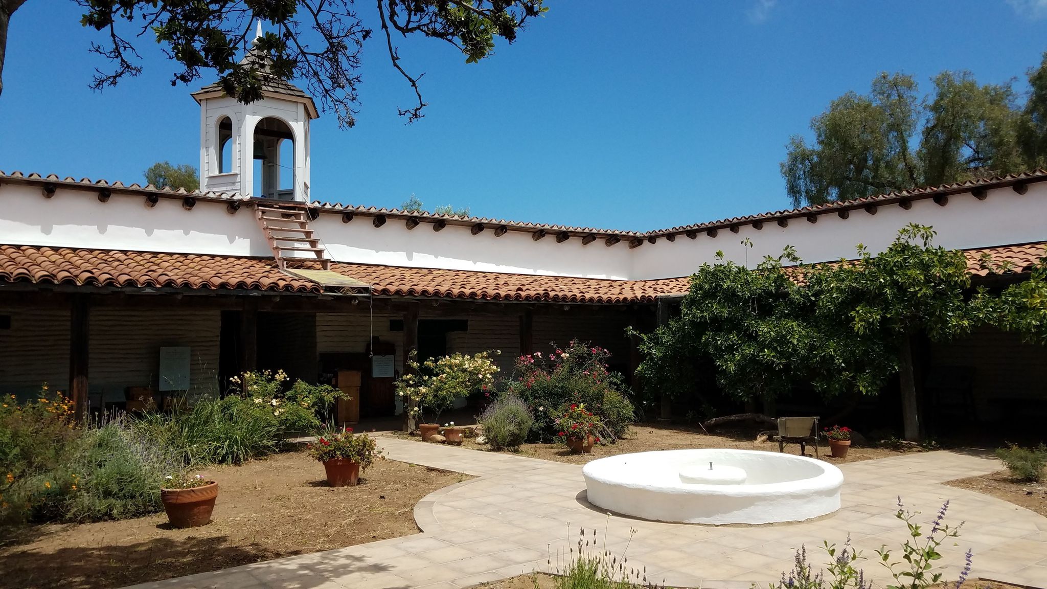 Photo of La Casa de Estudillo Courtyard with plants, a fountain, and paths