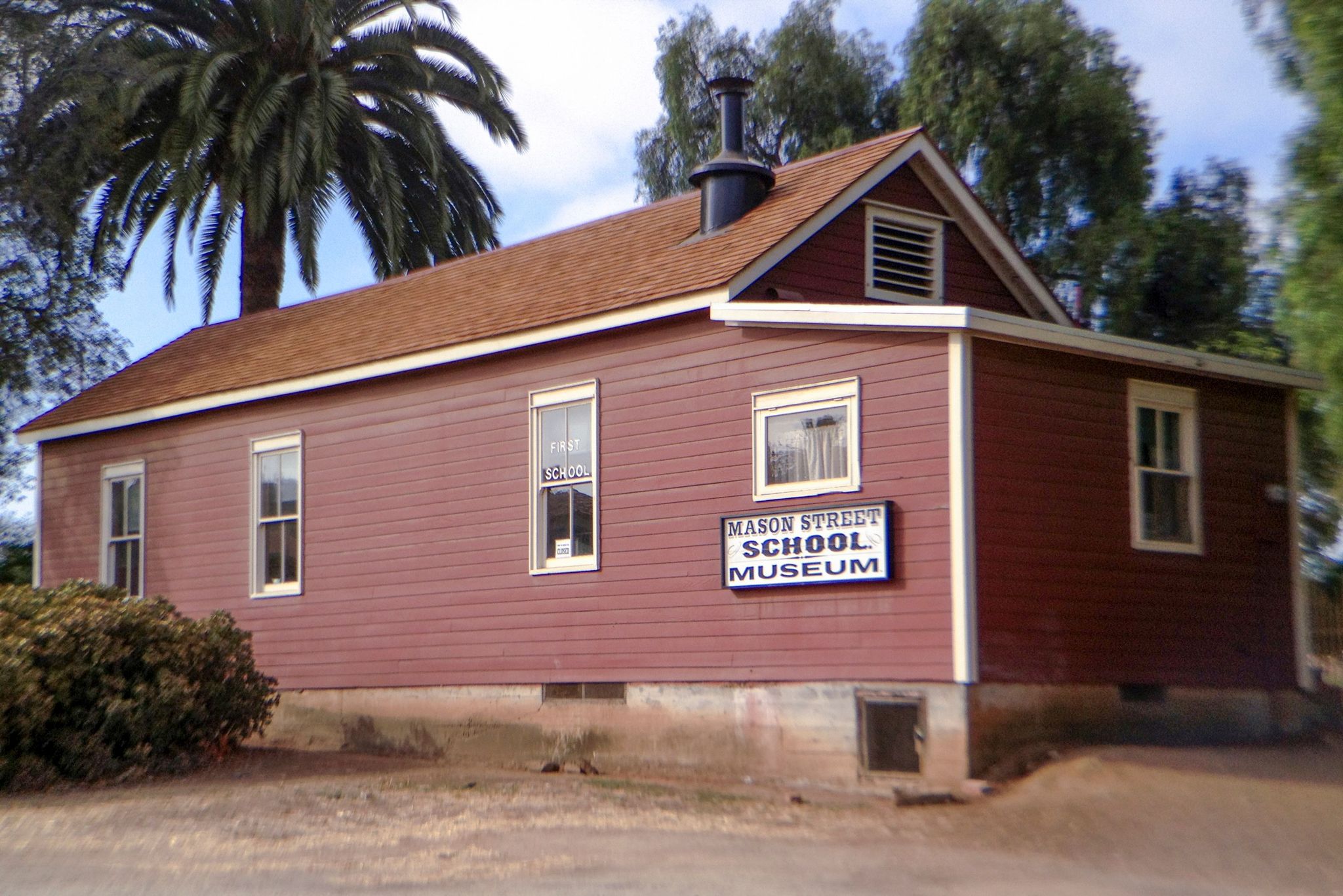 Photo of the exterior of the Schoolhouse with its sign.