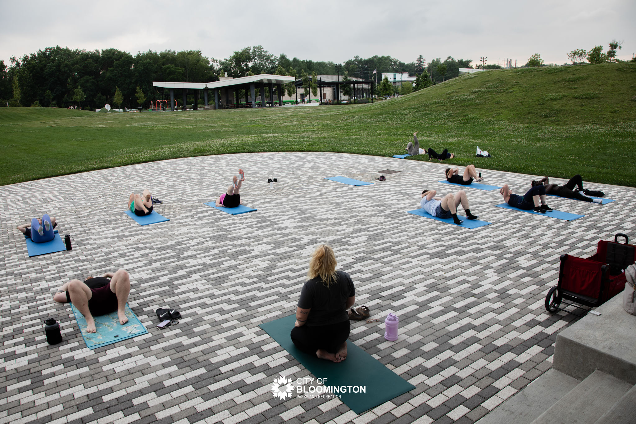 Overlooking group of adults doing yoga on performance stage at Switchyard Park