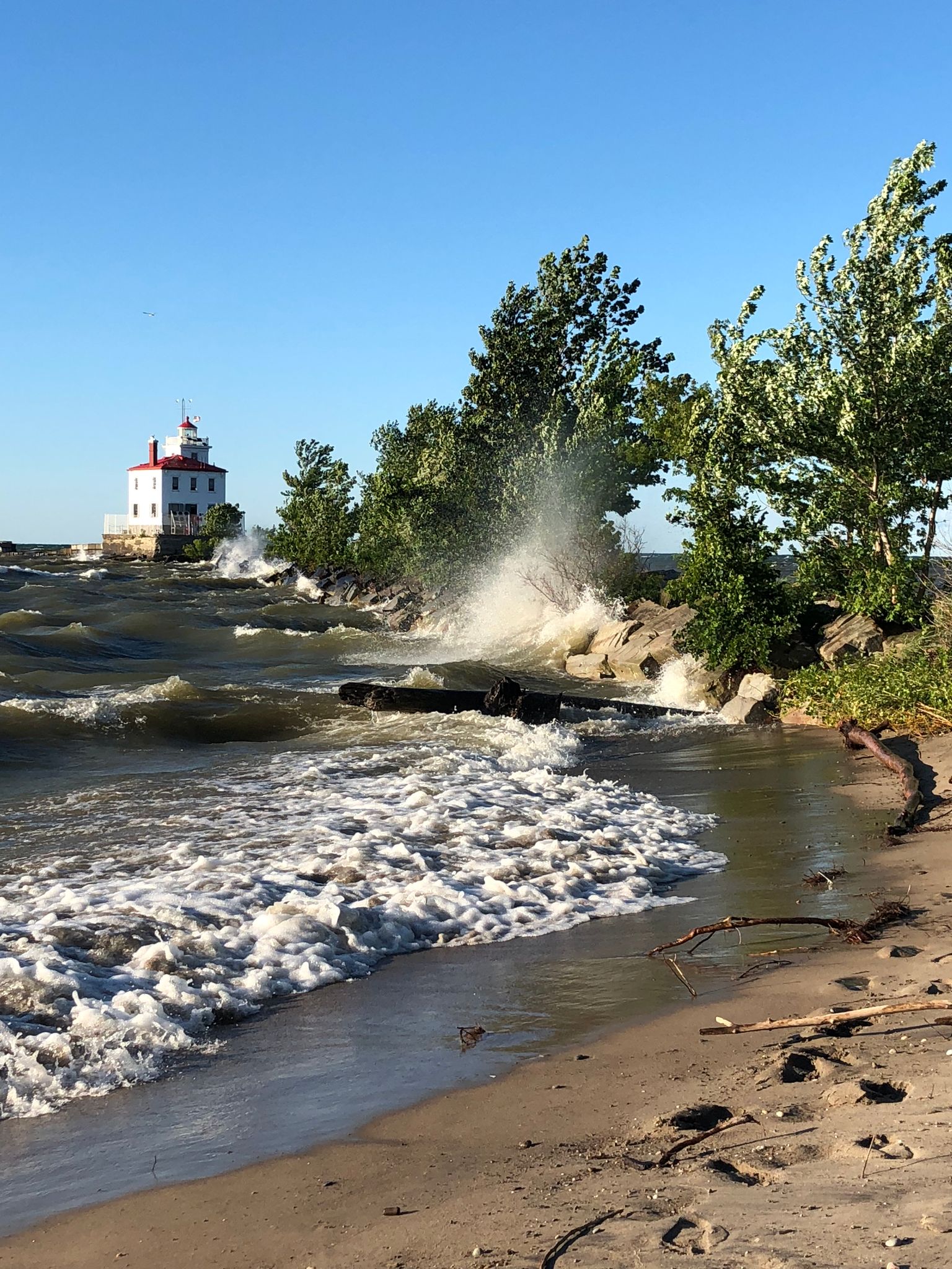 Fairport Harbor West Breakwater Light house at headlands beach with water splashing up against the rocks