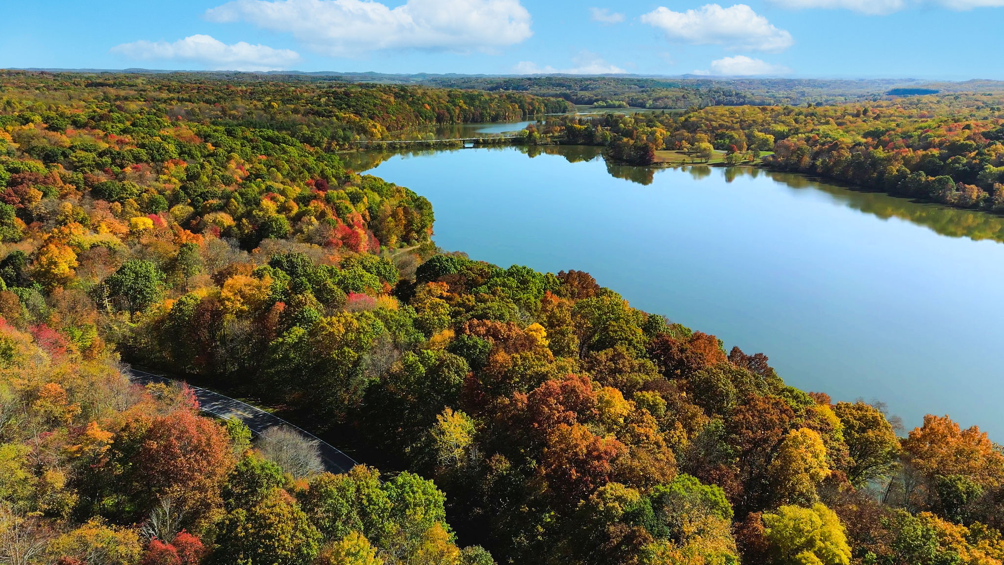 aerial view of salt fork state park lake with stunning fall foliage of trees and blue skies