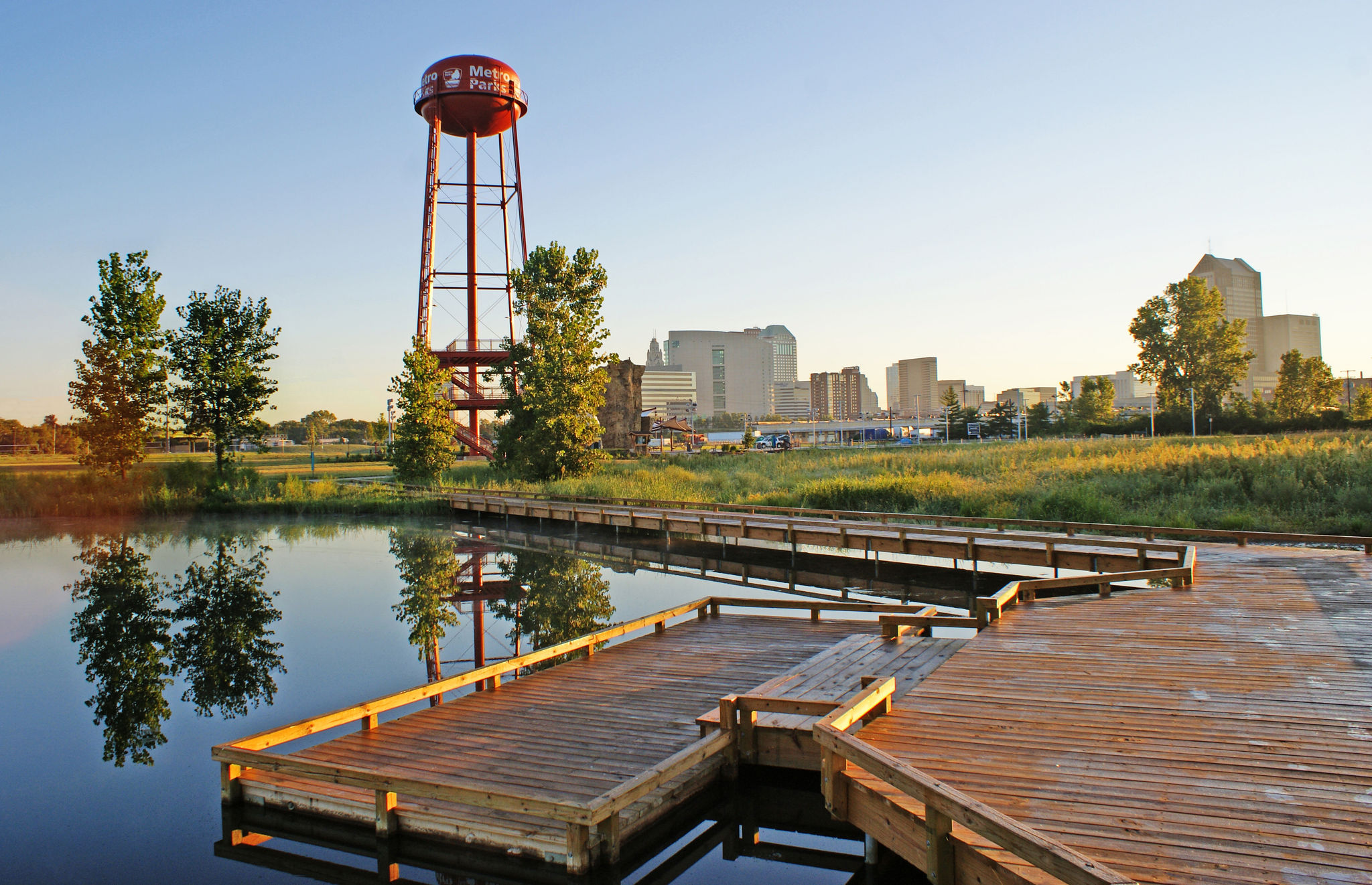 The water tower with logos with the wetland viewing deck and boardwak in the foreground.