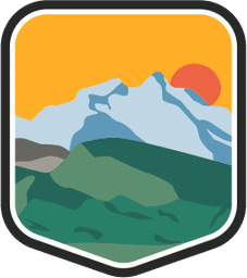 An illustrated badge for the Alaska community featuring a vast mountain range with snow-capped peaks with the sun setting behind the range.