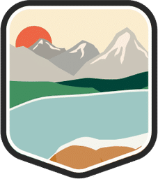 An illustrated badge for the Idaho community showing a lake surrounded by mountains with a clear sky.